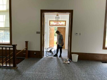 We did some more cleaning before we started setting up chairs for our first service on the new carpet.  <br />Judy is seen here checking things out