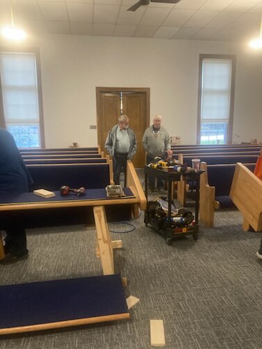 The pews being assembled.<br /><br />Dave and Lenney are the 2 men walking toward the front.